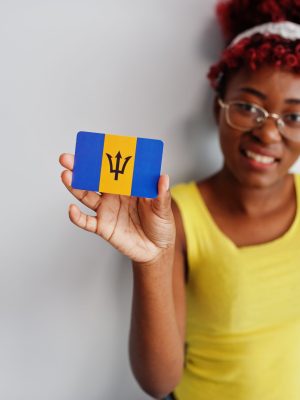 African american woman with afro hair, wear yellow singlet and eyeglasses, hold Barbados flag isolated on white background.