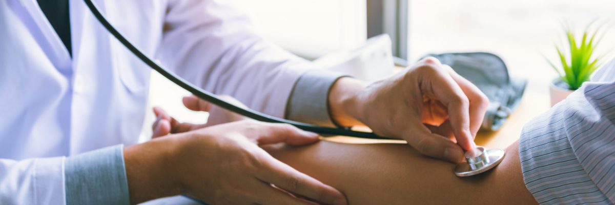 Asian doctor is using the stethoscope to touch the patient's arm.