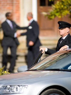 chauffeur-with-car-as-businessmen-shake-hands-at-m-2025-10-14-02-54-31-utc-scaled.jpg