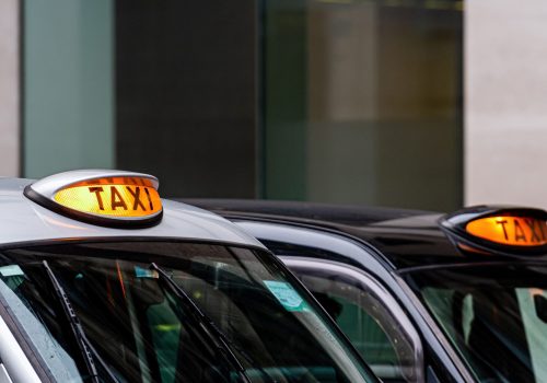 A british london black taxi cab sign with defocused  background - image
