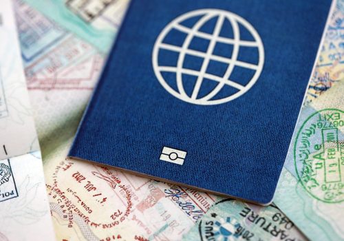 Many open passport pages with lots of visas and entrance stamps from various countries passport control. Concept of travel and tourism worldwide
