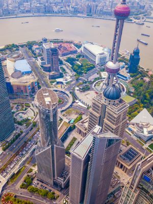 Aerial view of Shanghai Downtown, China. Financial district and business centers in smart city in Asia. Top view of skyscraper and high-rise office buildings at sunset.