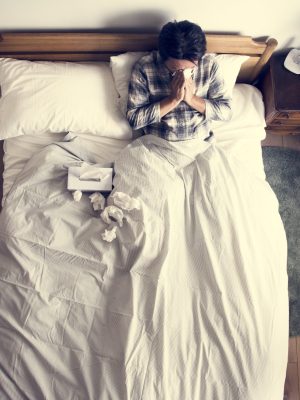 Sick Asian man blowing his nose