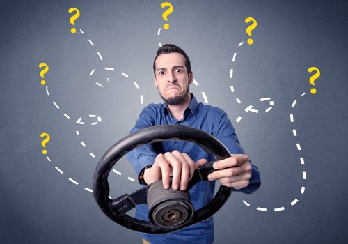 young-man-holding-black-steering-wheel-with-questi-2025-10-13-13-33-31-utc